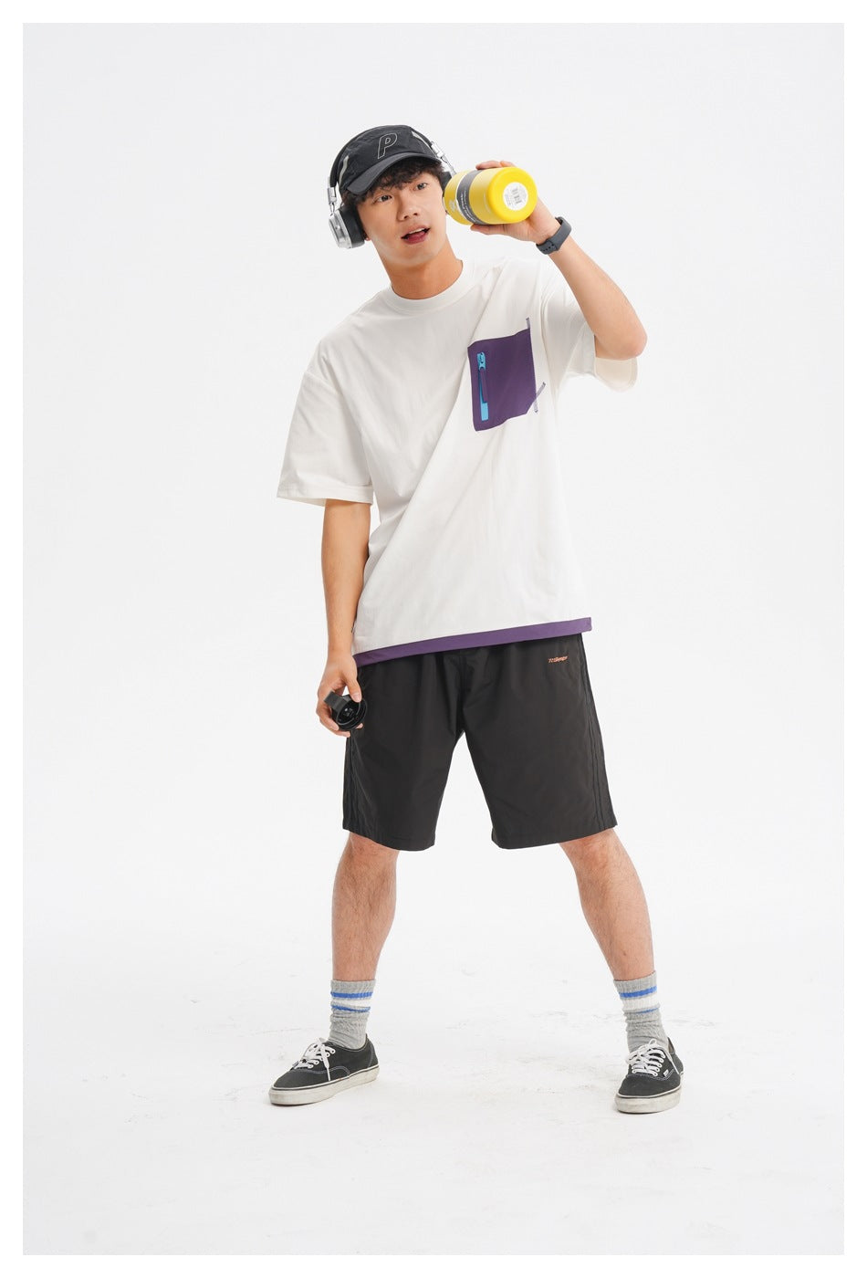 Front view of a model wearing a white oversized tee with a purple zip chest pocket and hem trim.