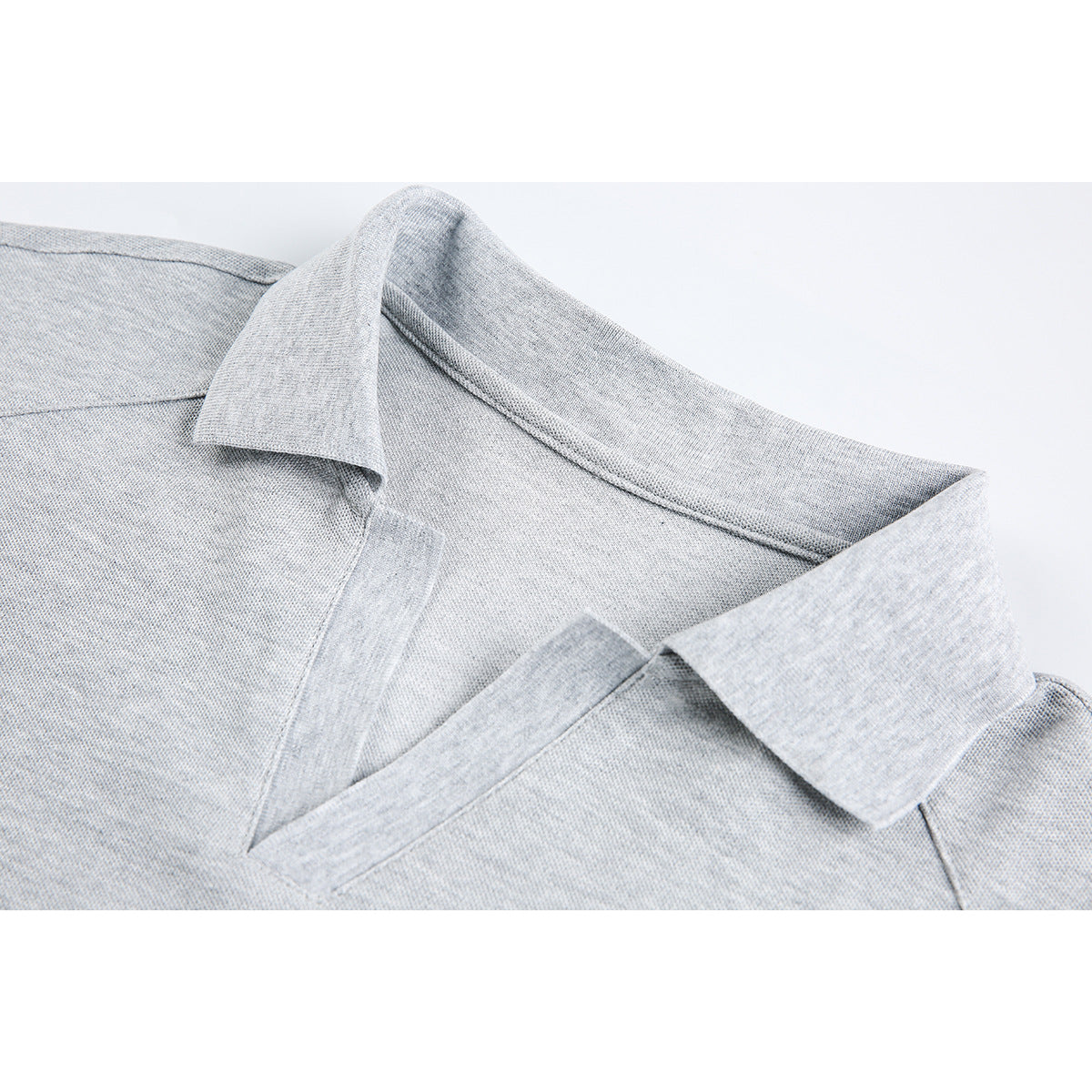 Close-up of a light gray polo shirt’s collar, neckline, and stitching.