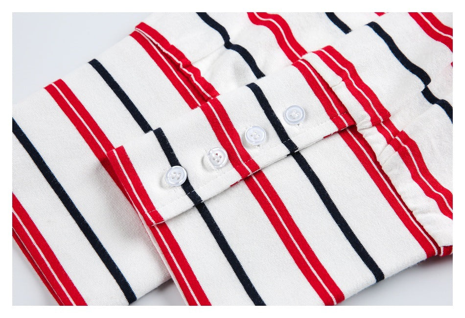 Close-up of a white shirt with red and navy stripes, showing its button placket and white buttons.