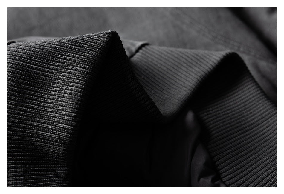 Close-up of dark ribbed knit trim on the charcoal jacket.