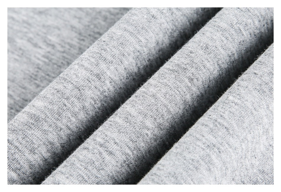 Close-up of light gray heathered knit fabric arranged in soft folds.