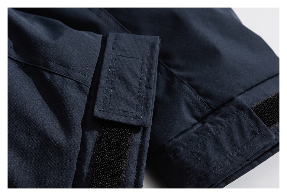 Close-up of a navy jacket cuff with an adjustable hook-and-loop strap.