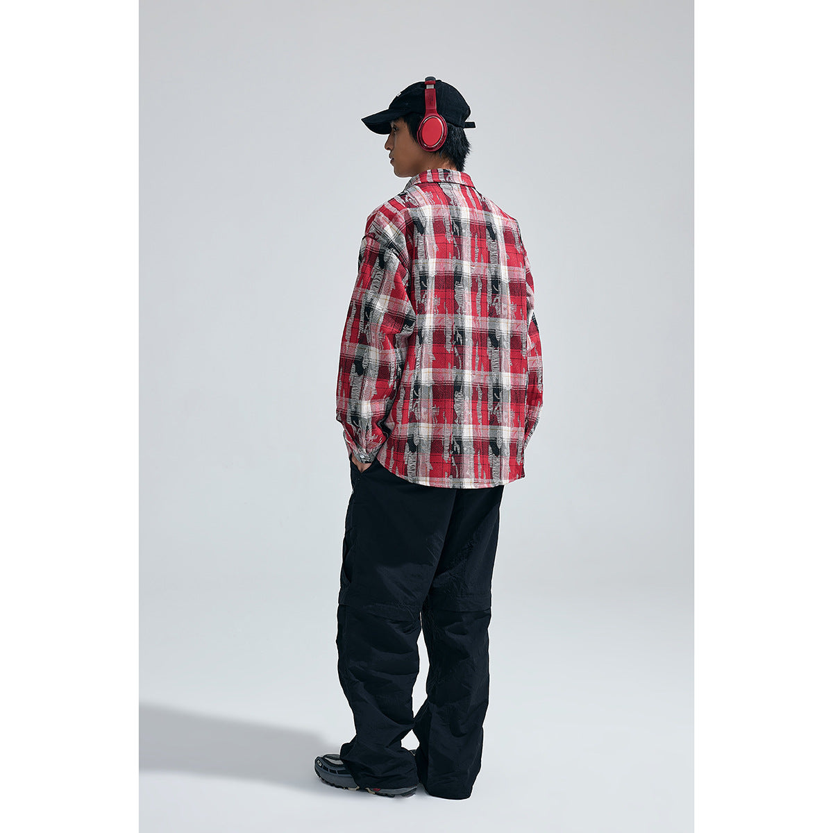Model shown from behind in a red, black and white plaid button-up shirt.