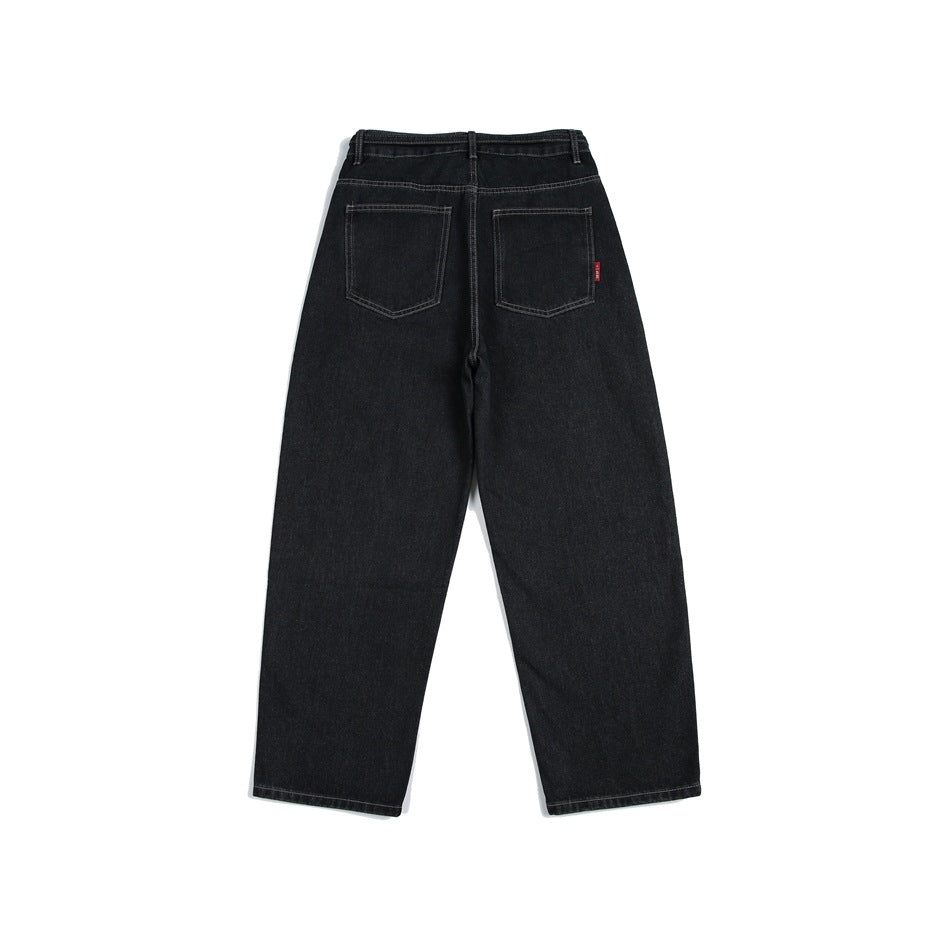 Back view of black, wide-leg jeans with two patch pockets and a small red pocket tab.