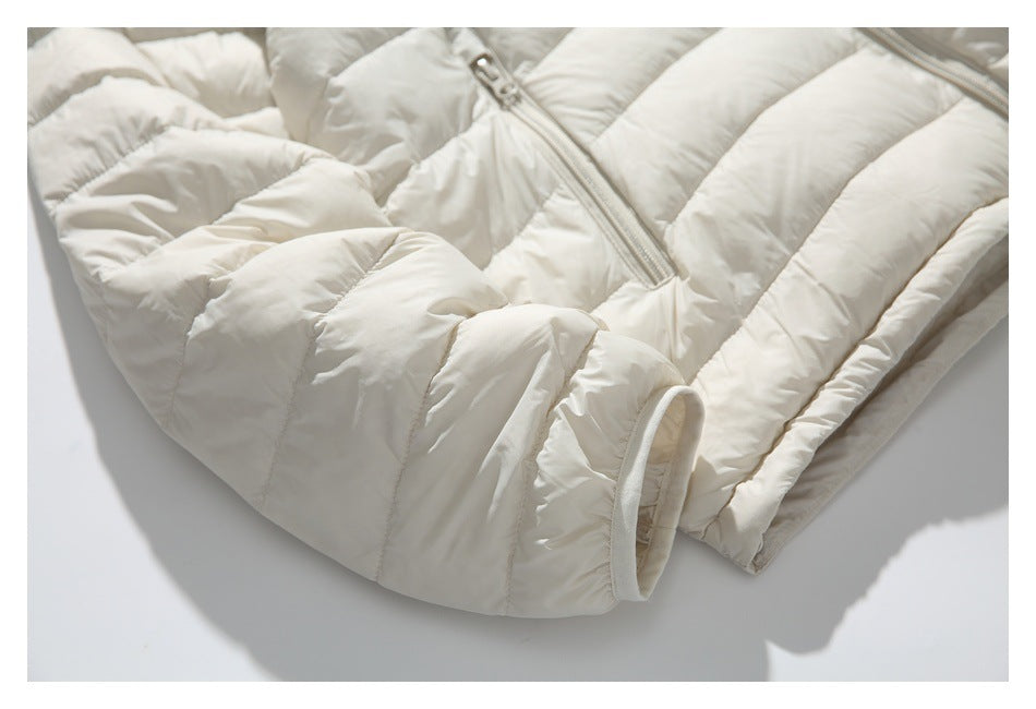 Close-up of the ivory quilted jacket's padded sleeve and elasticized cuff beside a zip pocket.