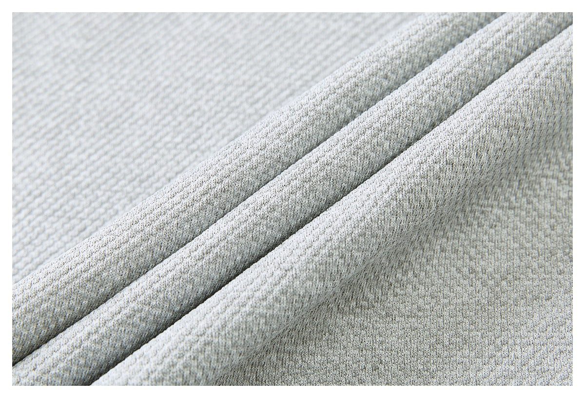 Macro view of the pale gray garment's textured knit fabric and folded edge.