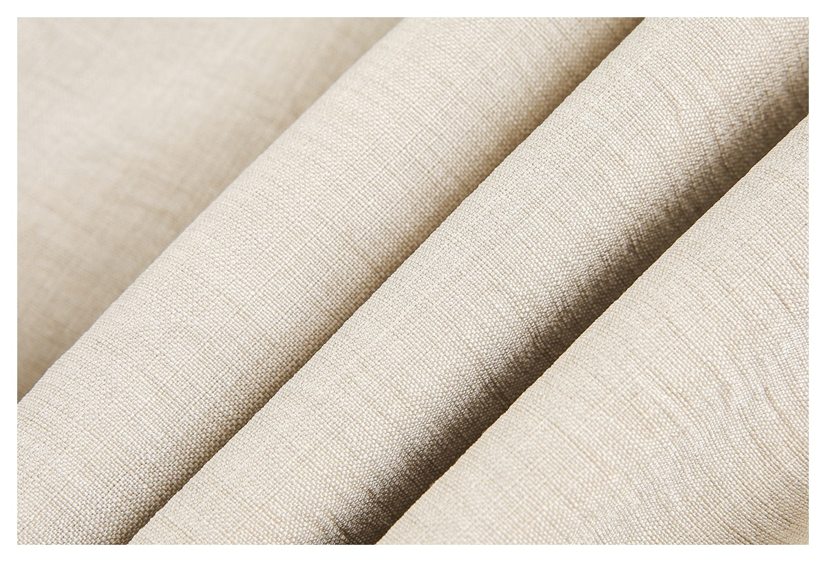 Close-up showing the woven surface and folds of beige garment fabric.