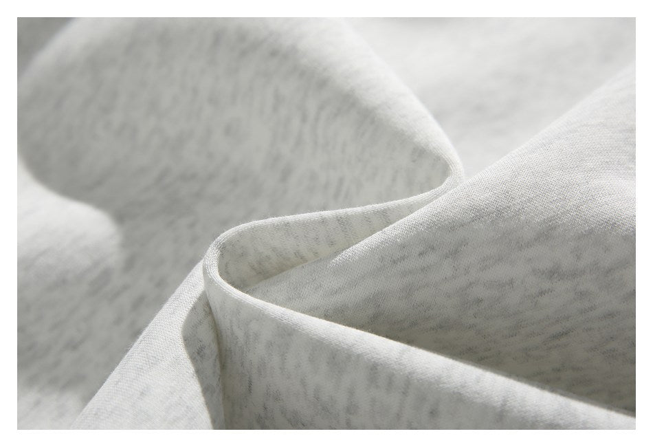 Close-up of softly mottled light gray fabric folded to show its surface and edge.