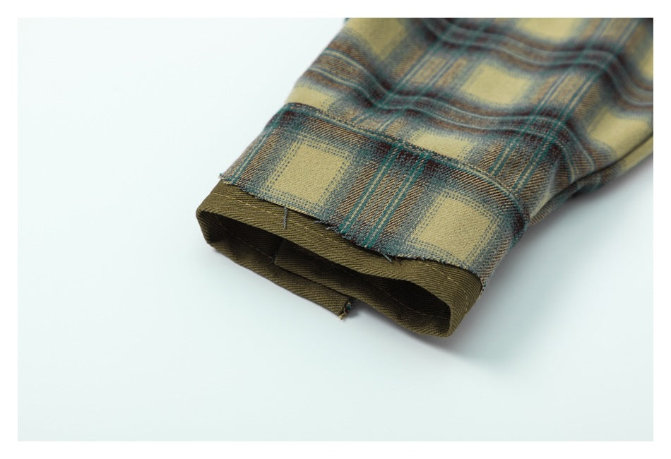 Close-up of a plaid shirt sleeve cuff showing its dark olive inner facing.