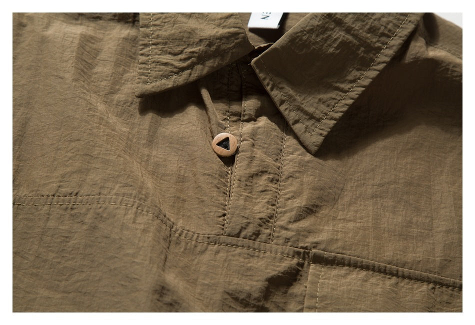 Close-up of a brown garment’s pointed collar, stitched front placket and single button.