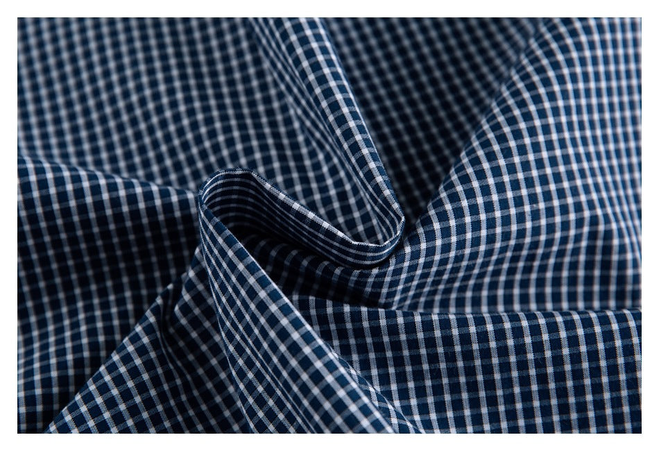 Close-up of navy-and-white checked shirt fabric gathered into folds.