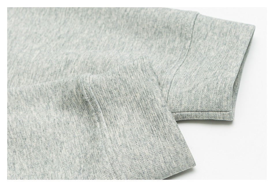 Close-up of a heather-gray sleeve and finished cuff with visible seam stitching.