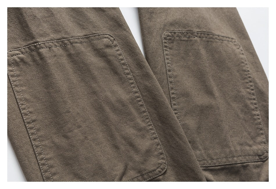 Close-up of two rectangular patch pockets on brown-gray garment fabric.