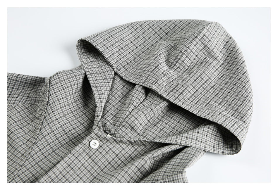 Close-up of the gray checked pullover's hood, neckline, and white button.