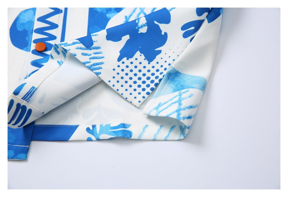 Close-up of the shirt's folded front edge, stitching, blue abstract print, and an orange button.