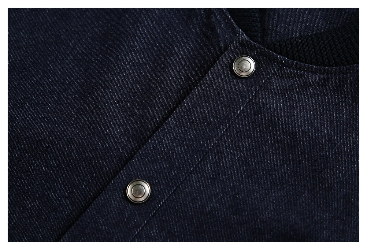 Close-up of a dark navy garment with a ribbed collar and two silver snap buttons.
