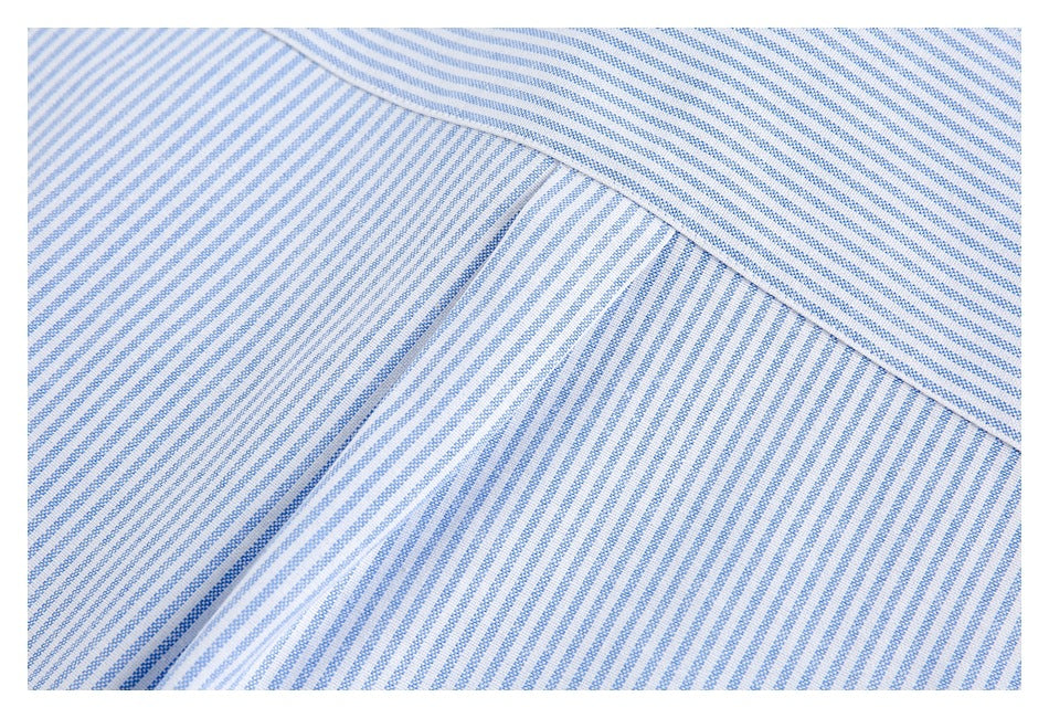Close-up of white fabric with fine blue diagonal stripes and a folded seam.