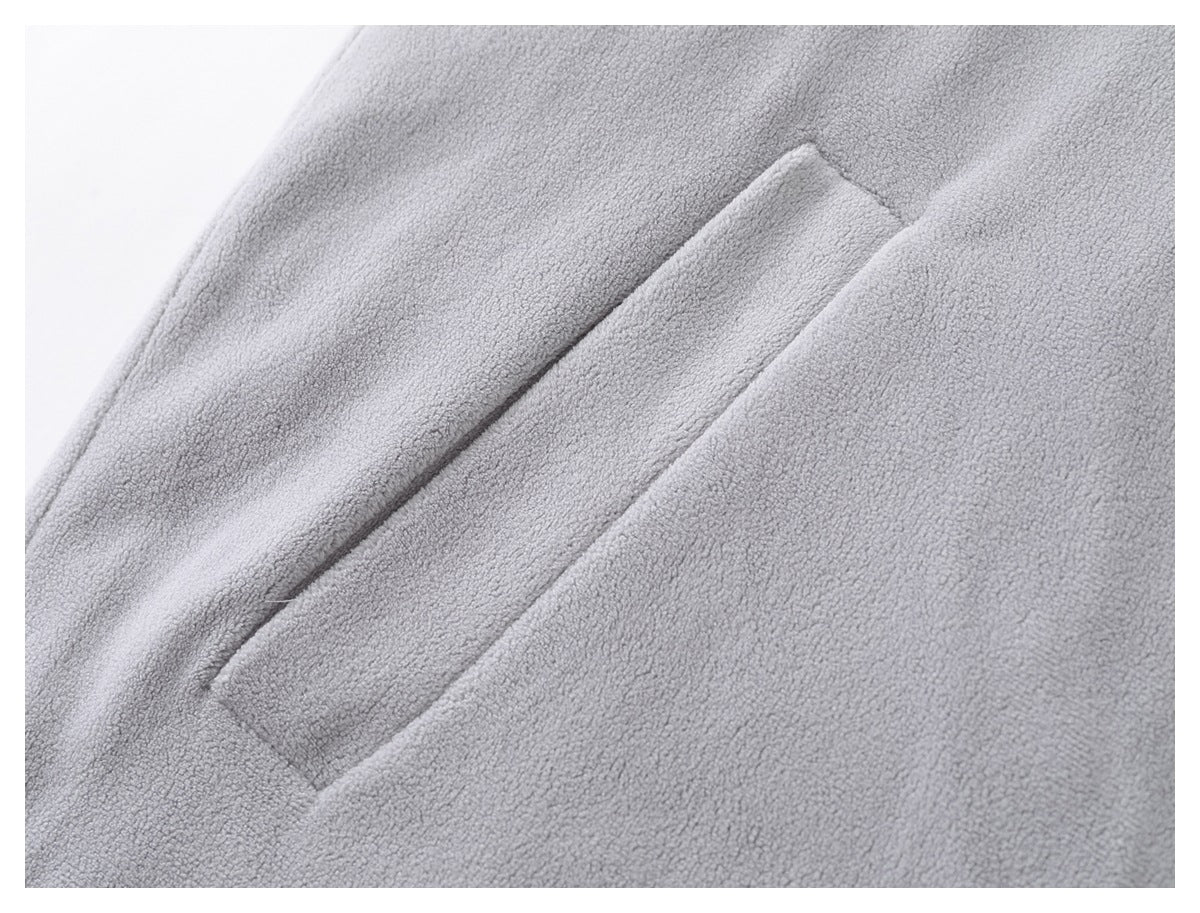 Close-up of a diagonal welt pocket on the light gray fleece jacket.