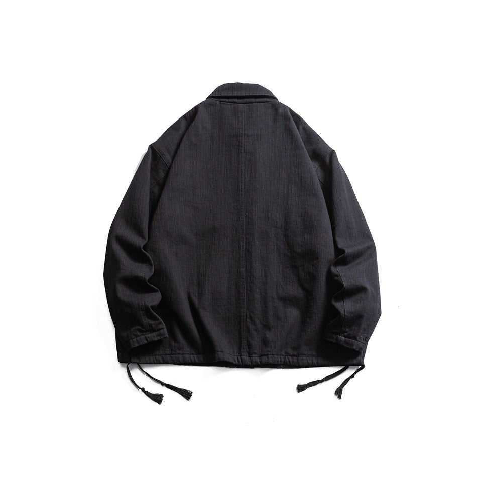 Back view of a black jacket with a collar, long sleeves, and dangling hem ties, laid flat on white.