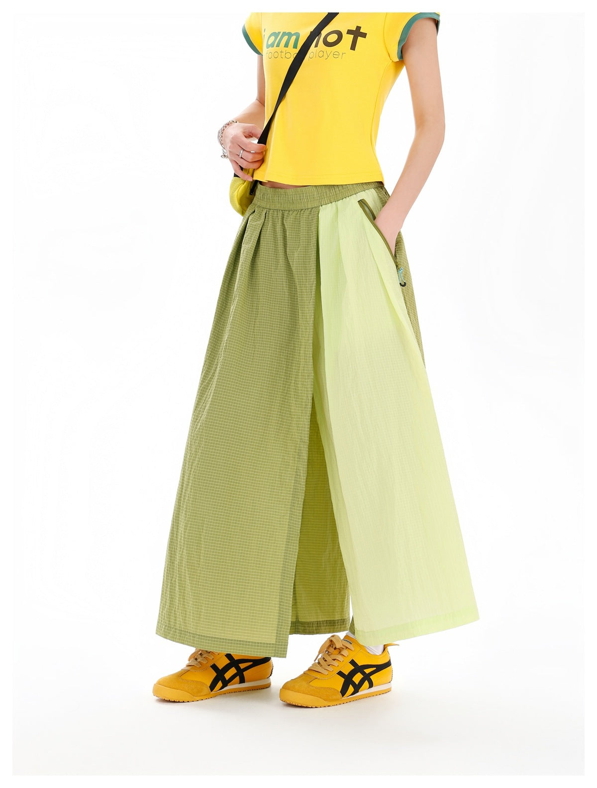 Three-quarter view of a model in an olive checked and pale-chartreuse color-block maxi skirt and yellow T-shirt.