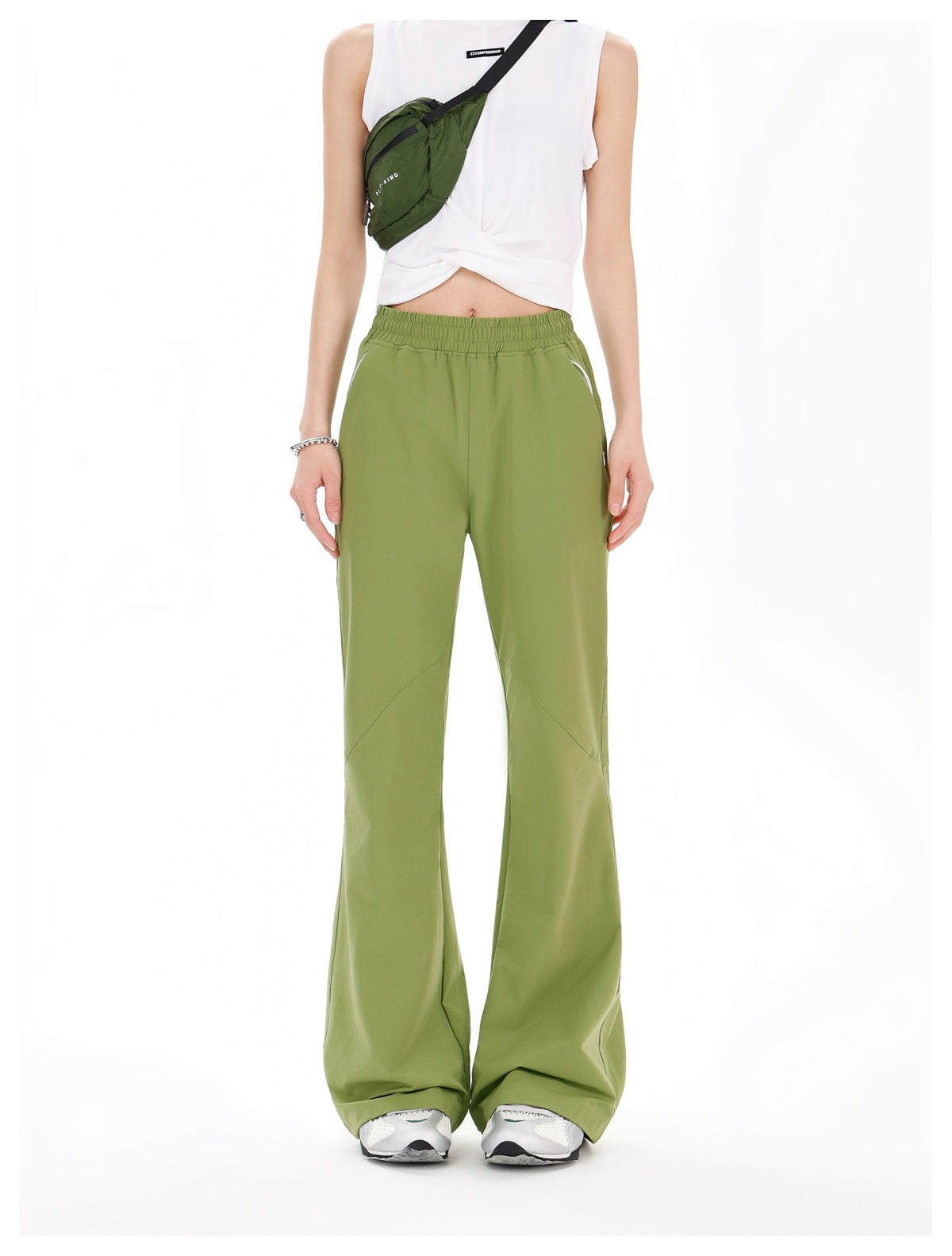 Front view of a model wearing olive-green wide-leg pants with an elastic waist and white sneakers.