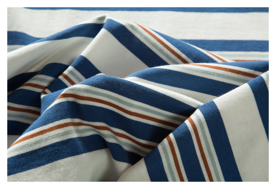 Draped close-up of a garment with broad blue and cream stripes and narrow pale green and rust stripes.