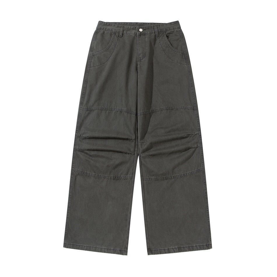 Front view of dark gray washed wide-leg pants with knee seams, curved front pockets and button zip fly