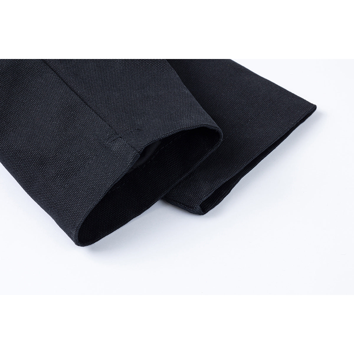 Close-up of the cuff and folded sleeve of a dark jacket.