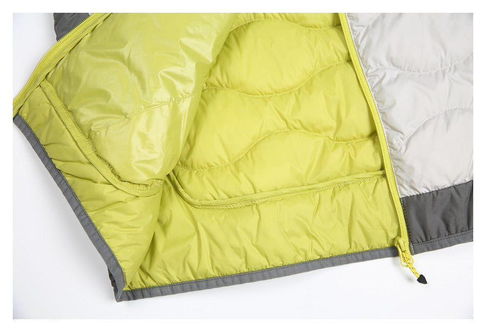 Close-up of an open quilted jacket showing lime-yellow lining, an interior pocket, zipper, and gray trim.