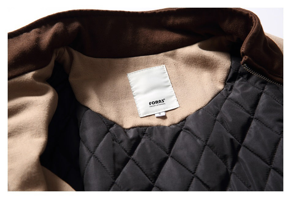 Close-up of the jacket's interior black quilted lining, tan collar, and sewn brand label.