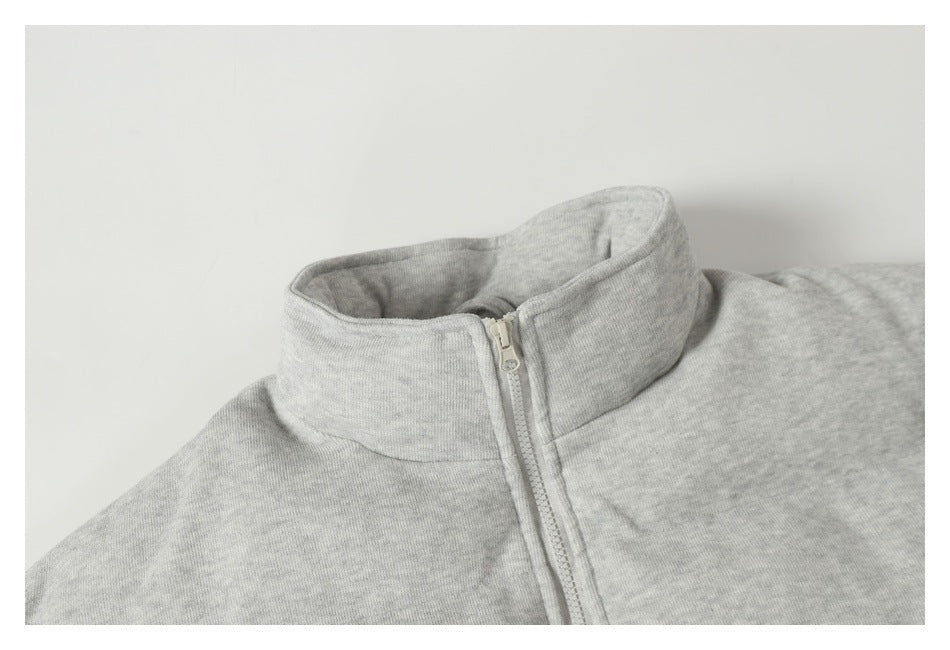Close-up of the light gray jacket's tall collar and front zipper.