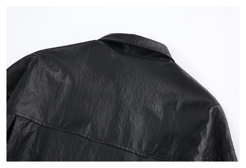 Close-up of the back shoulder yoke and collar of a black textured jacket.