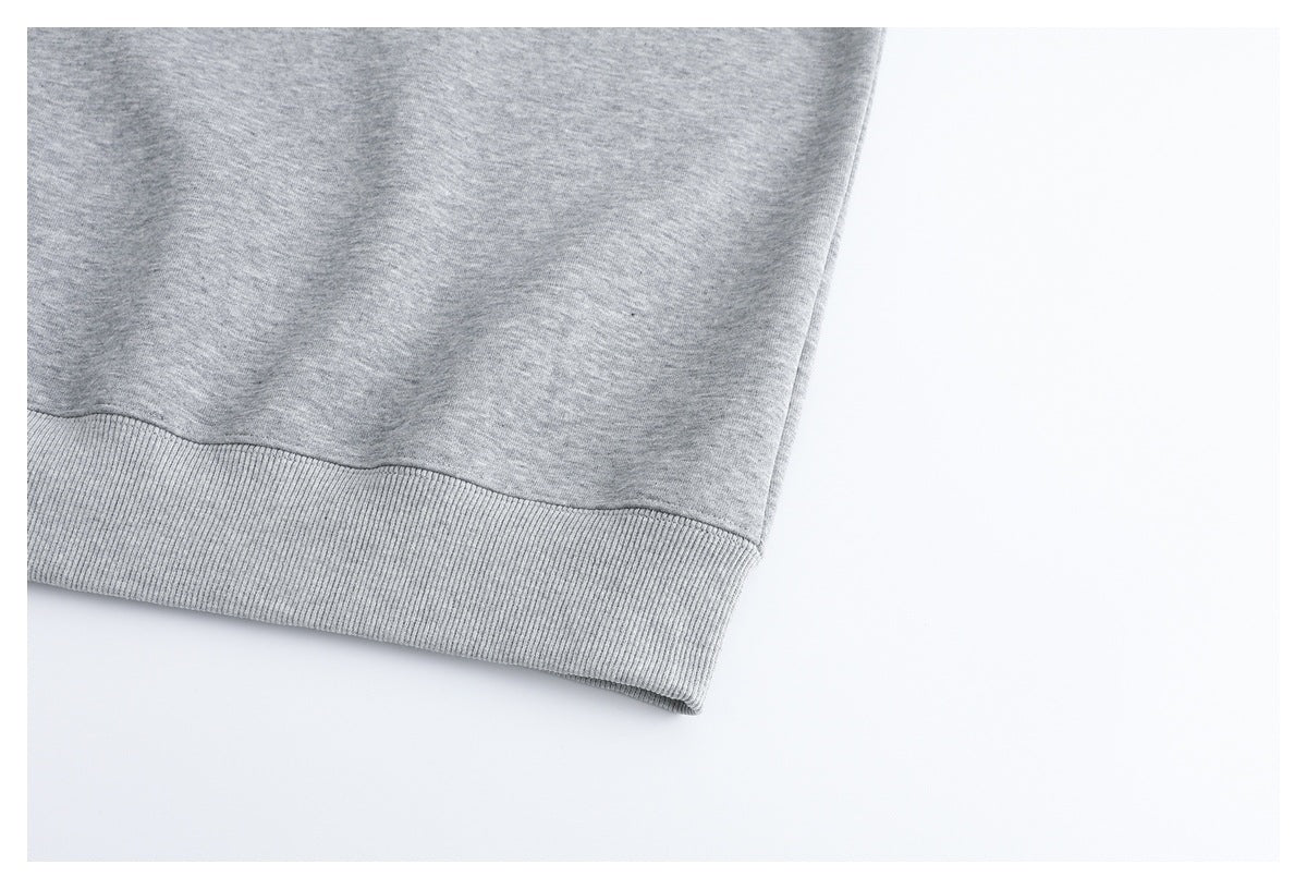 Close-up of a heather gray sweatshirt hem with a wide ribbed band.