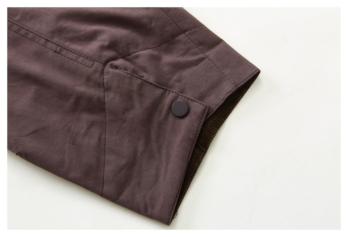 Close-up of a mauve-brown jacket cuff with a dark snap fastener and dark ribbed lining.