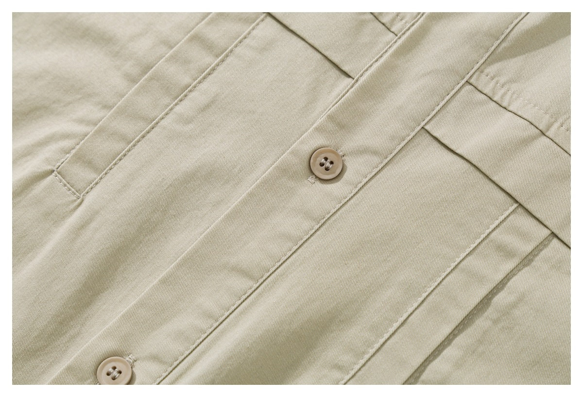 Close-up of beige shirt fabric, button placket, stitching, and buttons.
