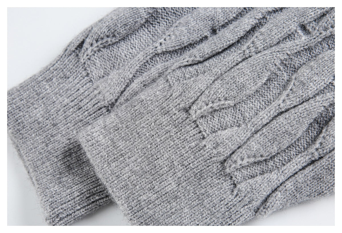 Close-up of a ribbed cuff and cable-knit fabric on a gray sweater.