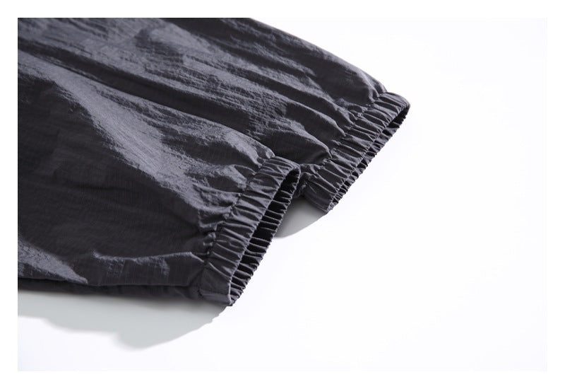 Close-up of two gathered elastic cuffs on charcoal gray garment sleeves.