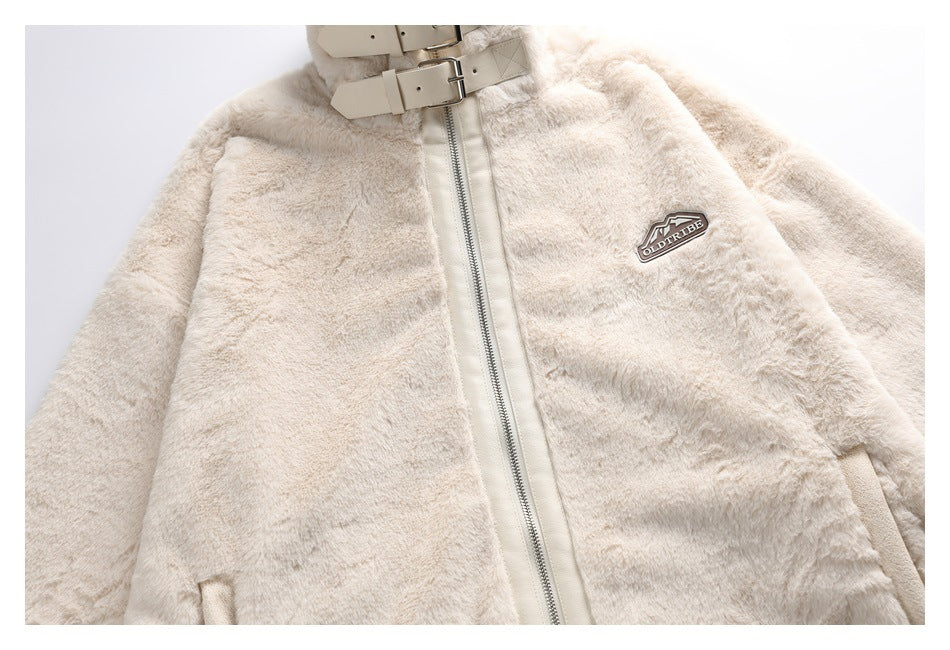 Partial front view of an ivory faux-fur jacket with a silver zipper, buckle collar, and OLDTRIBE chest patch.