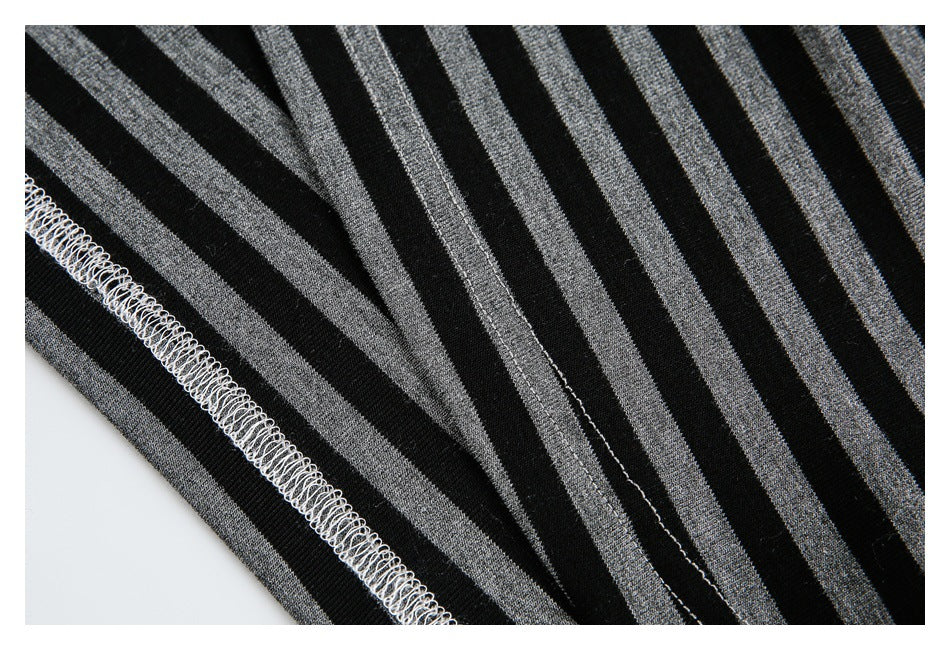 Close-up of black fabric with gray stripes, showing the garment's stitched edge and seam.