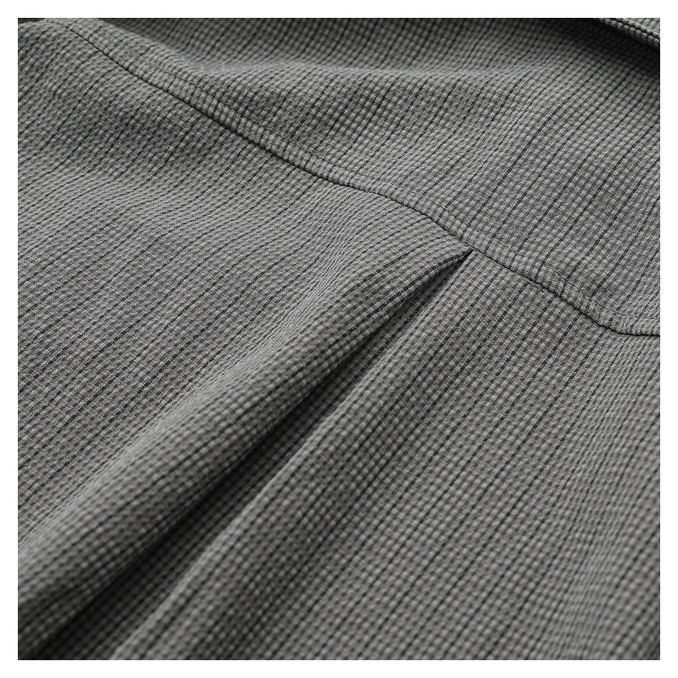 Close-up of gray micro-check shirt fabric and a curved stitched seam.