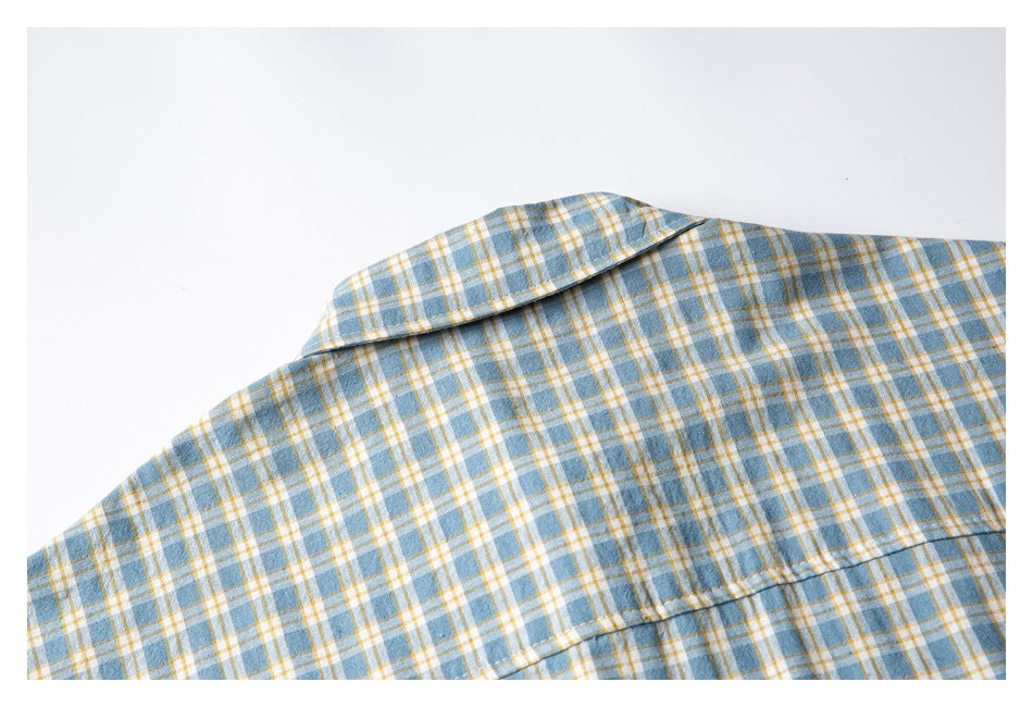 Close-up of the back collar and yoke seam on a blue, white, and mustard plaid shirt.
