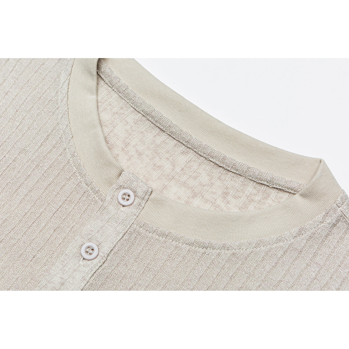 Close-up of a cream knit shirt’s ribbed crew neckline and two-button placket.