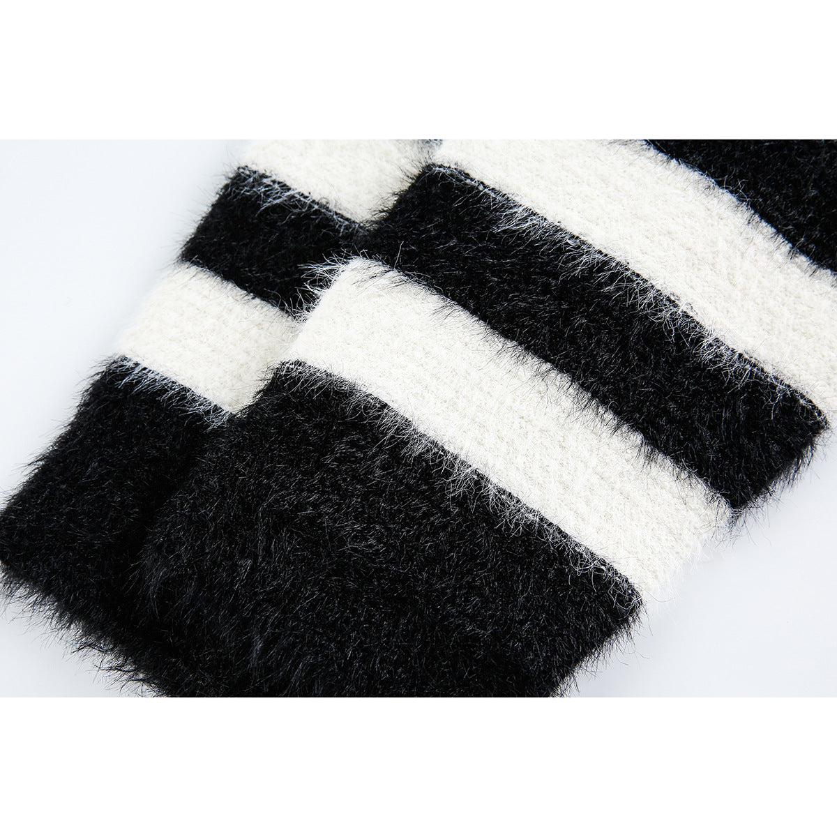 Close-up of a fuzzy black-and-ivory striped knit sleeve or edge.