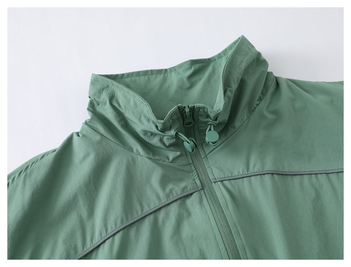 Close-up of a sage-green jacket’s high collar, center zipper, and curved piping.