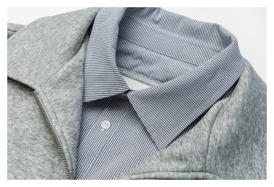 Close-up of a gray jacket with a silver zipper and a blue-and-white pinstriped shirt-style collar.