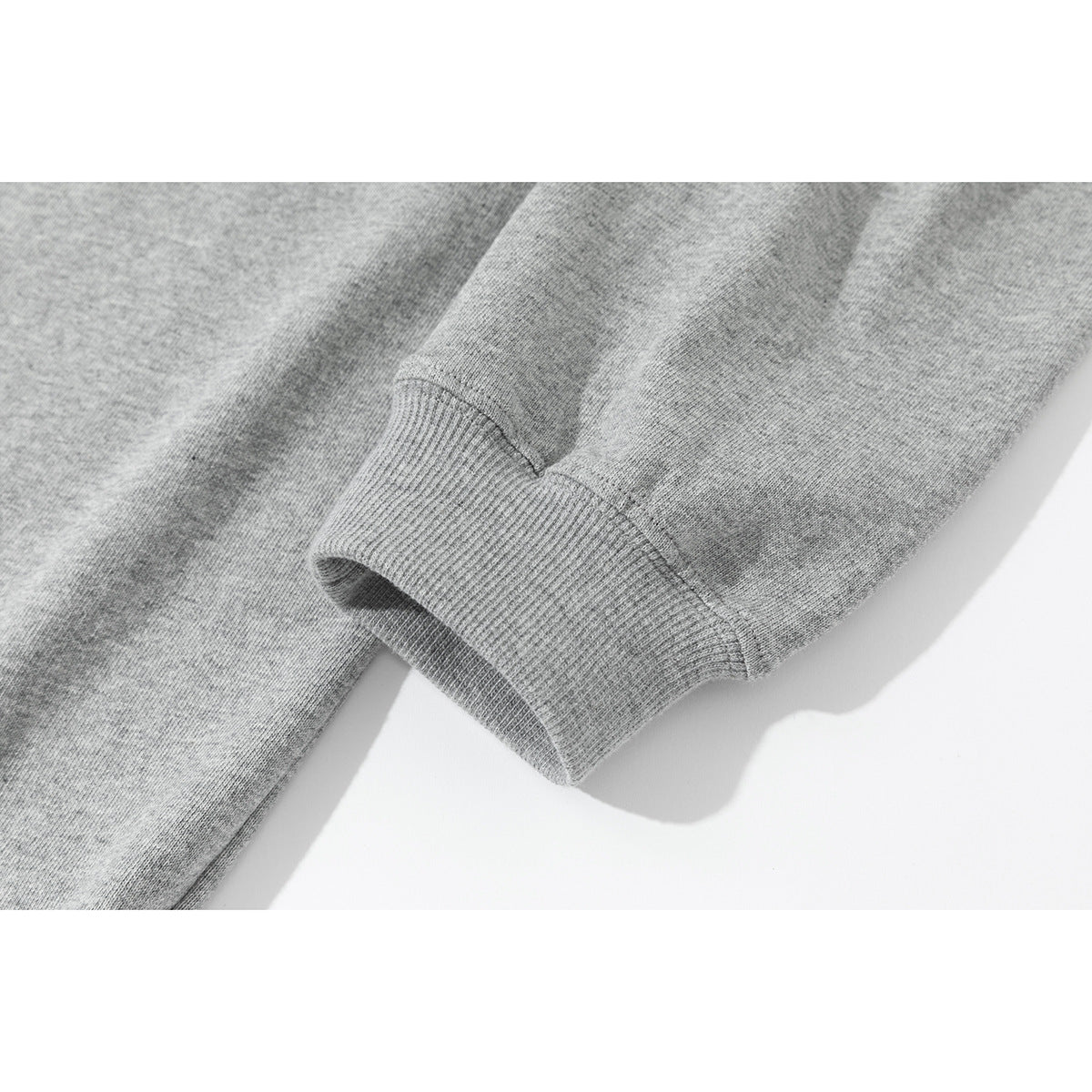 Close-up of a heather-gray shirt sleeve and ribbed cuff.