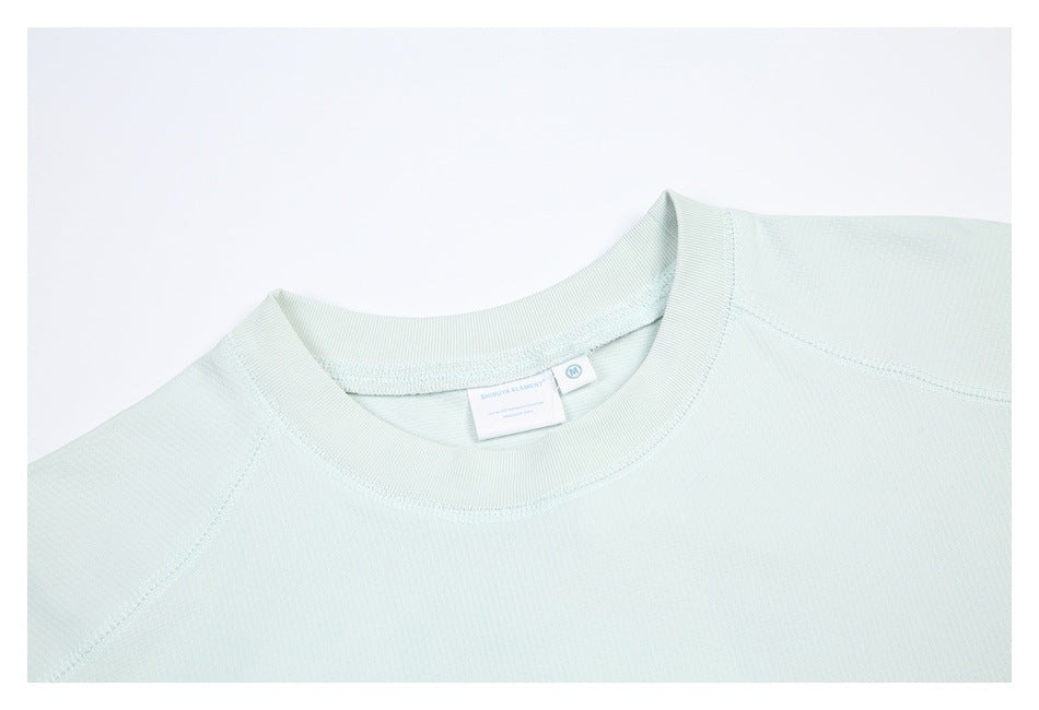 Close-up of the mint shirt's crew neckline, shoulder seams, and sewn-in label.