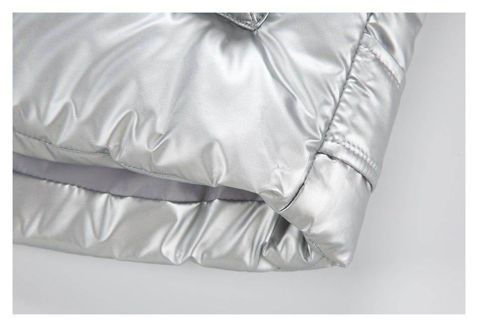 Close-up of a padded, stitched edge and seam on shiny silver outerwear.