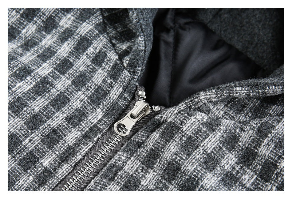 Close-up of a gray plaid jacket's silver zipper pull, teeth, and dark hood lining.