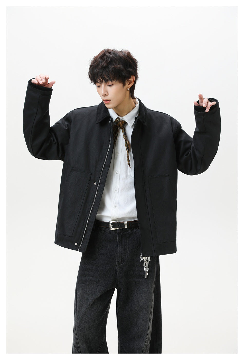 Model wearing a black oversized jacket with a zip front and two large patch pockets, arms raised.
